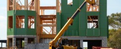 yellow and black heavy equipment near unfinished building
